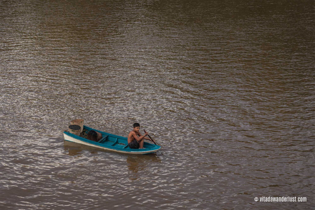 Un bambino in canoa in attesa che gli venga regalato qualcosa